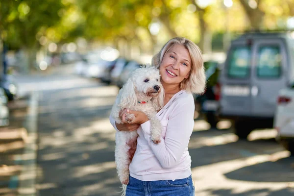 Femme âgée marchant avec un chien à l'extérieur — Photo