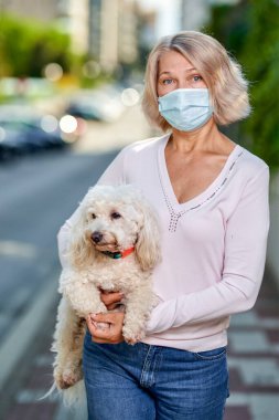 Dışarıda köpekli yaşlı kadın portresi antivirüs maskesi..