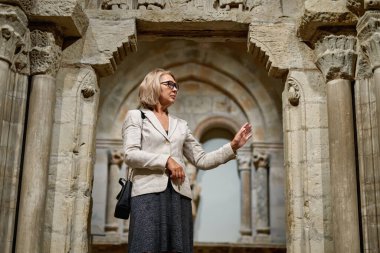 Sanat galerisindeki antik yapıya bakan kadın.