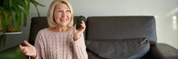 Senior Vrouw Met Behulp Van Mobiele Telefoon Tijdens Het Zitten — Stockfoto