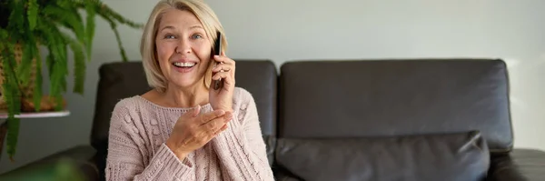 Senior Mulher Usando Telefone Celular Enquanto Sentado Sofá — Fotografia de Stock