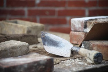 Bu fotoğraf bir duvarcı çalışmalarını gösteriyor. Bu örmek görüntü bir mala, kalıp veya tuğla ile birlikte dökme içerir. Tuğla döşeme işini özel yetenek ister.