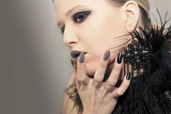 迷人的哑光黑灰色化妆 并在一个黑色背景上的模型羽毛尖锐的椭圆形指甲上修甲 — 图库照片