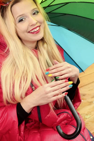 Autumn nail design.Multicolored manicure on a young cheerful girl with long hair with an umbrella .Nail art.