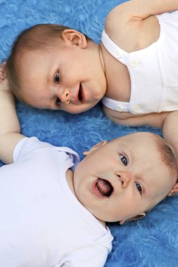 Meraklı, komik ve farklı duygular bebekler üzerinde mavi arka plan ile.