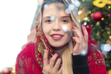 Yeni yıl için kışın bir kırmızı geleneksel fularlı genç gülümseyen güzel Rus kız.