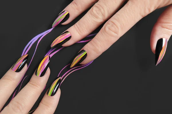 Colorful bright manicure with different sharp shape of nails framed with black lacquer.Nail art. Creative nail design on black background.