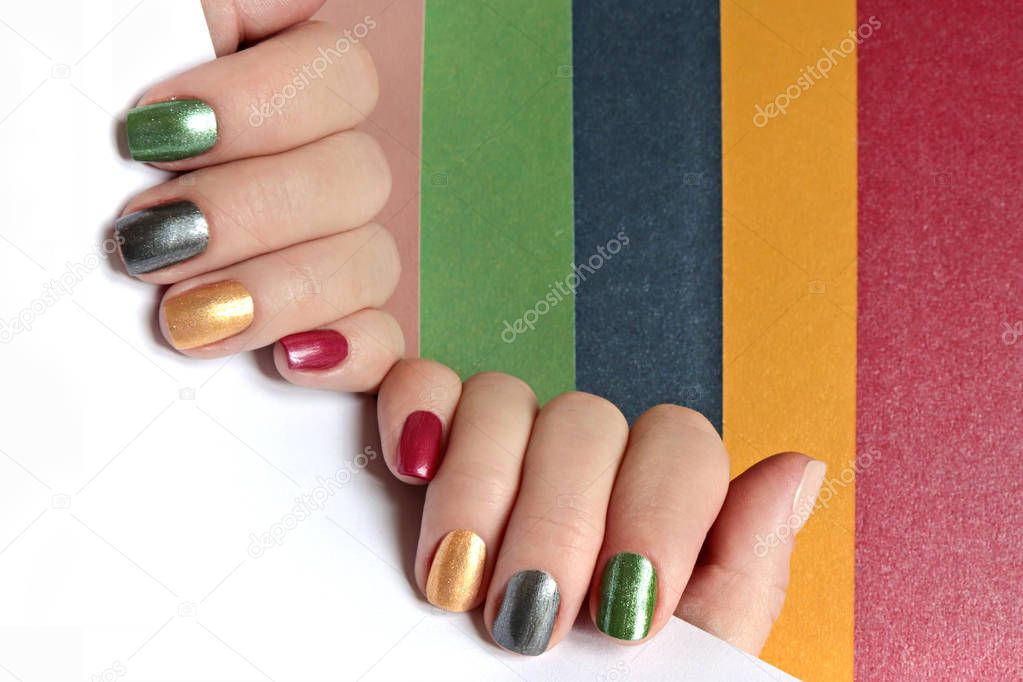 Multi-colored mother of pearl manicure on short nails.Nail art.Nail design red,green,gray,beige,Golden yellow nail Polish.
