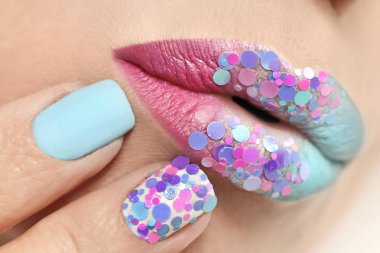 Creative multi-colored pastel make-up of lips and nails with round glitters. Fashionable manicure with different shape of nails and varnish. clipart