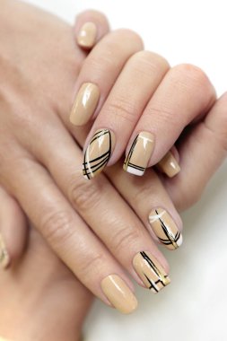 Manicure on different nail shapes with black lines on beige nail Polish with sequins. clipart