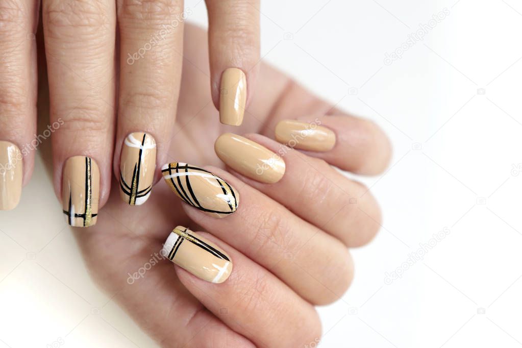 Manicure on different nail shapes with black lines on beige nail Polish with sequins.