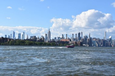 New York City - Haz 30: Manhattan Manzarası, New York, Brooklyn'deki Domino Park'tan, 30 Haziran 2019'da görüldüğü gibi. New York, ABD'nin nüfusa göre en büyük şehridir ve yıllık milyonlarca ziyaretçisi vardır..