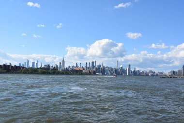 New York City - Haz 30: Manhattan Manzarası, New York, Brooklyn'deki Domino Park'tan, 30 Haziran 2019'da görüldüğü gibi. New York, ABD'nin nüfusa göre en büyük şehridir ve yıllık milyonlarca ziyaretçisi vardır..