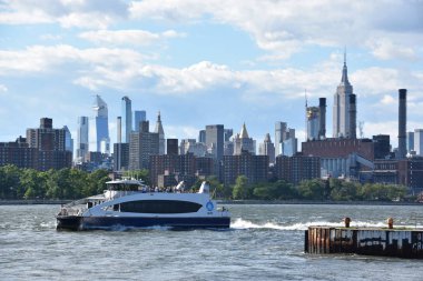 New York City - Haz 30: Manhattan Manzarası, New York, Brooklyn'deki Domino Park'tan, 30 Haziran 2019'da görüldüğü gibi. New York, ABD'nin nüfusa göre en büyük şehridir ve yıllık milyonlarca ziyaretçisi vardır..