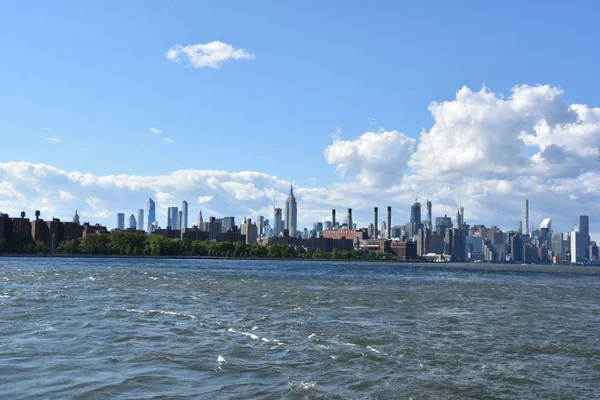 New York City - Haz 30: Manhattan Manzarası, New York, Brooklyn'deki Domino Park'tan, 30 Haziran 2019'da görüldüğü gibi. New York, ABD'nin nüfusa göre en büyük şehridir ve yıllık milyonlarca ziyaretçisi vardır..