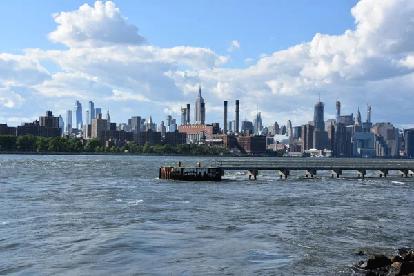 New York City - Haz 30: Manhattan Manzarası, New York, Brooklyn'deki Domino Park'tan, 30 Haziran 2019'da görüldüğü gibi. New York, ABD'nin nüfusa göre en büyük şehridir ve yıllık milyonlarca ziyaretçisi vardır..