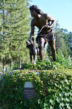 COOPERSTOWN, NY - 24 Temmuz 2020 'de New York eyaletinin Cenevre kentindeki Lakefront Park' ta John Quincy Adams Ward tarafından yapılan Hint Avcı heykeli.