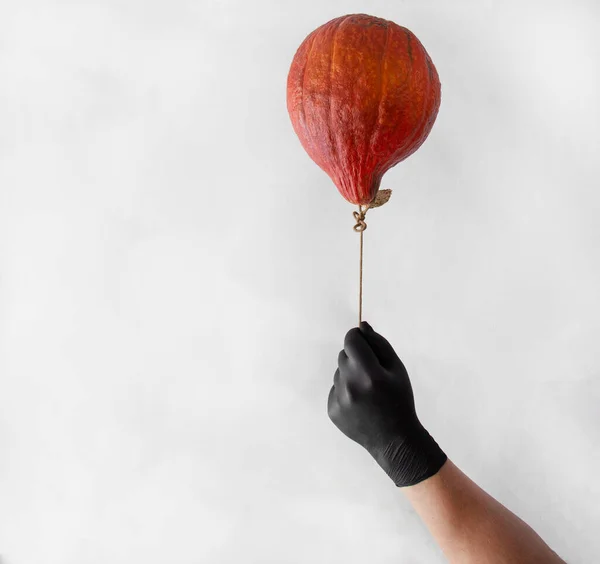 Balon şeklinde bir balon. Koronovirüsten korunmak için siyah eldivenli bir adam.