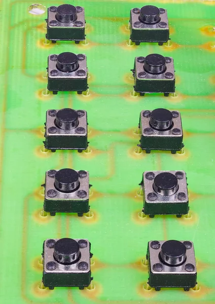 Petits boutons noirs sur une carte de circuit imprimé verte — Photo