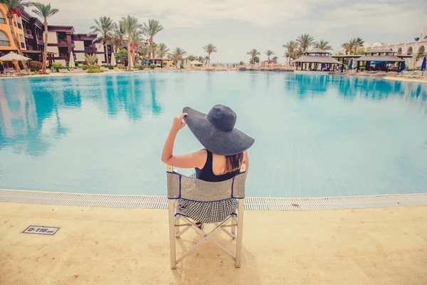 Mulher de chapéu preto perto da piscina — Fotografia de Stock