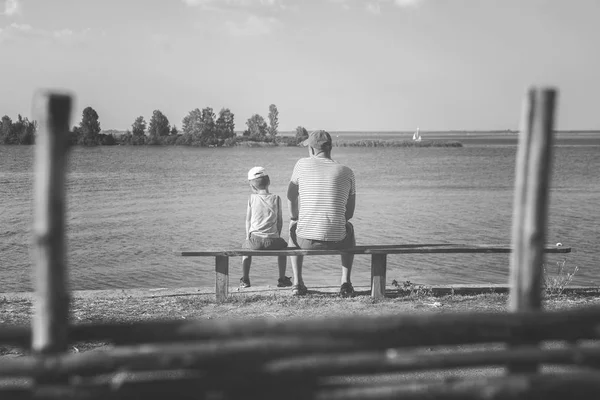 Father and son sitting on a bench — Stock Photo, Image