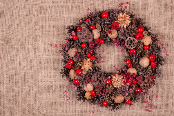 Eski bir kahverengi kumaş üzerinde Noel çelenk — Stok fotoğraf