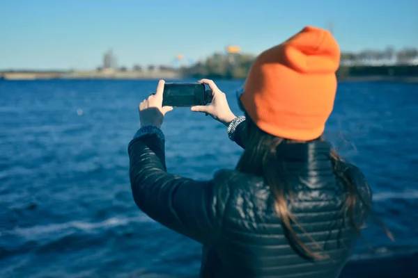 The girl is taking a photo of the river — Stock Photo, Image