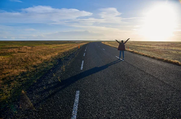 Mujer en un camino vacío con las manos en alto — Foto de Stock