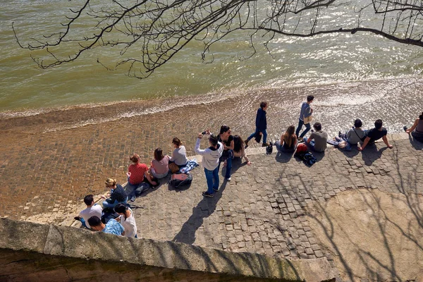 İnsanlar Sein Nehri'nin kıyısında.