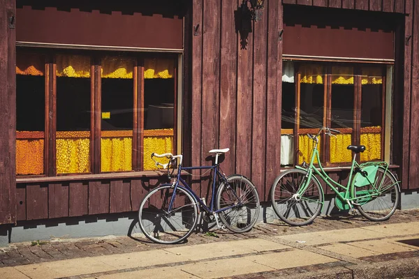 Duas bicicletas perto de uma parede de madeira — Fotografia de Stock