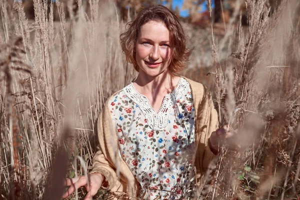 Mooie vrouw in de hoge herfst gras — Stockfoto