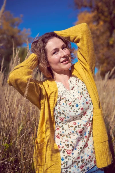 Pretty woman in the high autumn grass — Stock Photo, Image