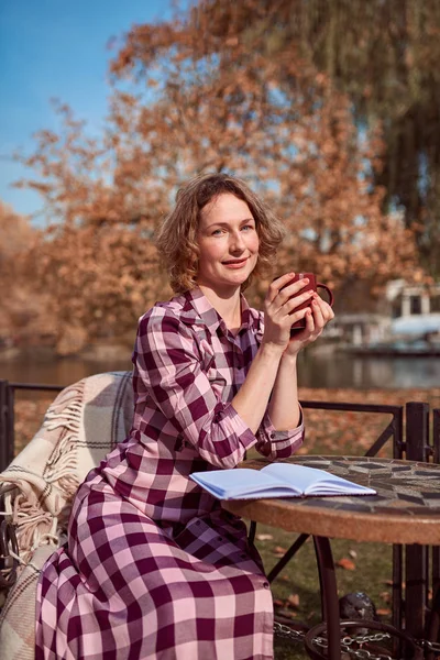 Vacker kvinna på ett kafé i höst — Stockfoto