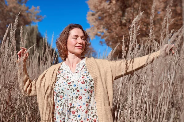 Mujer bonita en la hierba alta de otoño — Foto de Stock