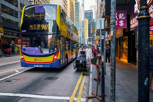 Doppeldeckerbus und ein Mann mit Trolley unterwegs in Hongkong — Stockfoto