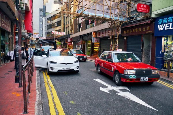 Tesla und Taxi unterwegs im Stadtzentrum von Hongkong — Stockfoto