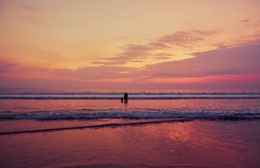 İnsanlar gün batımında plajda. Bali.