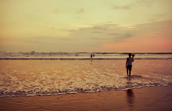 People on the beach at sunset. Bali. — Stock Photo, Image