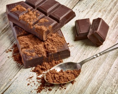 Tahta arka planda çikolata parçalarını kapat