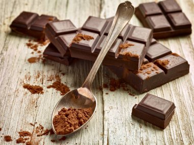 Tahta arka planda çikolata parçalarını kapat