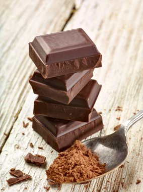 Tahta arka planda çikolata parçalarını kapat