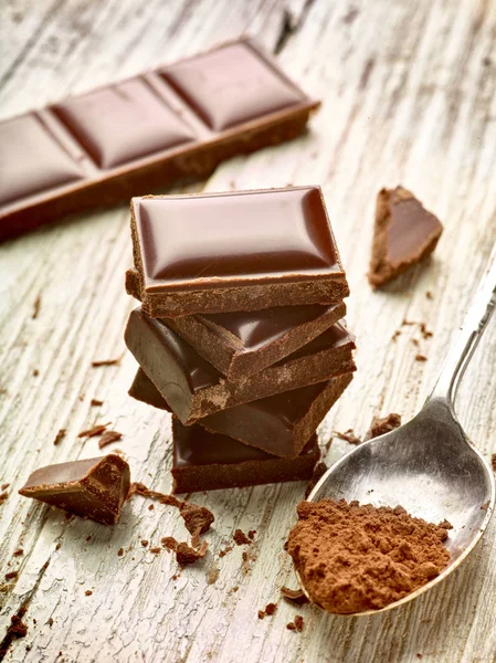 Tahta Arka Planda Çikolata Parçalarını Kapat — Stok fotoğraf