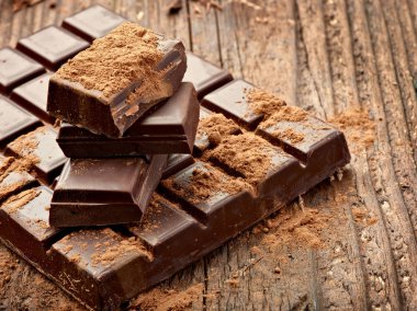 Tahta arka planda çikolata parçalarını kapat