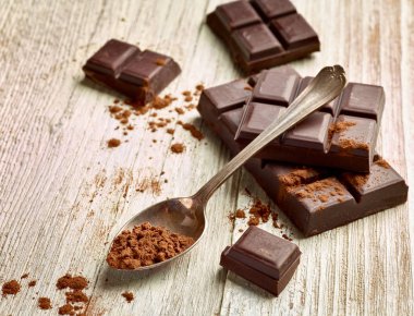 Tahta arka planda çikolata parçalarını kapat