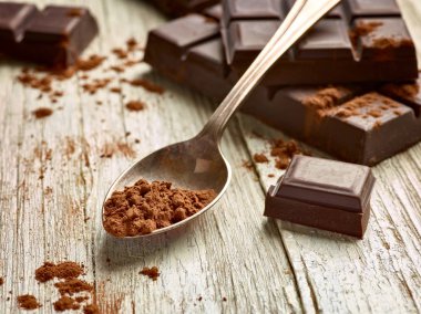 Tahta arka planda çikolata parçalarını kapat