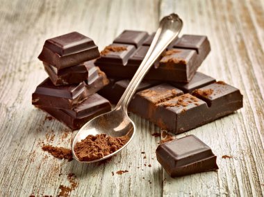 Tahta arka planda çikolata parçalarını kapat