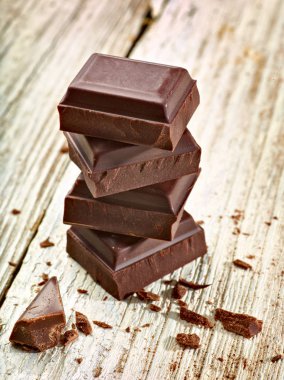 Tahta arka planda çikolata parçalarını kapat