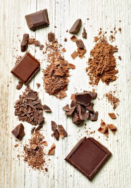 Tahta arka planda çikolata parçalarını kapat