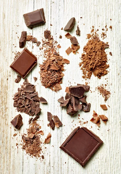 Tahta arka planda çikolata parçalarını kapat