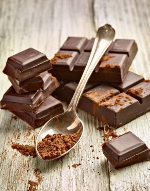 Tahta arka planda çikolata parçalarını kapat